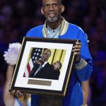 
              Kareem Abdul-Jabbar holds up a picture of himself receiving the Presidential Medal of Freedom from President Obama during halftime of an NCAA college basketball game between UCLA and Arizona, Saturday, Jan. 21, 2017, in Los Angeles. Abdul-Jabbar received the framed picture during a ceremony to celebrate Kareem Abdul-Jabbar day at UCLA. (AP Photo/Mark J. Terrill)
            