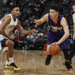 Phoenix Suns guard Devin Booker, right, drives to the net as Denver Nuggets guard Gary Harris defends in the second half of an NBA basketball game Thursday, Jan. 26, 2017, in Denver. The Nuggets won 127-120. (AP Photo/David Zalubowski)