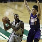 San Antonio Spurs Jonathon Simmons, left, drive to the basket as Phoenix Suns Devin Booker tries to block him, in the first half of their regular-season NBA basketball game in Mexico City, Saturday, Jan. 14, 2017. (AP Photo/Rebecca Blackwell)