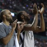 San Antonio Spurs Tony Parker, left, and teammate Kawhi Leonard applaud from the bach during a play in the first half of their regular-season NBA basketball game in Mexico City, Saturday, Jan. 14, 2017. (AP Photo/Rebecca Blackwell)