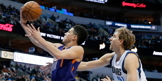 Phoenix Suns' Devin Booker, left, gets by Dallas Mavericks' Dirk Nowitzki, right, of Germany on a d...