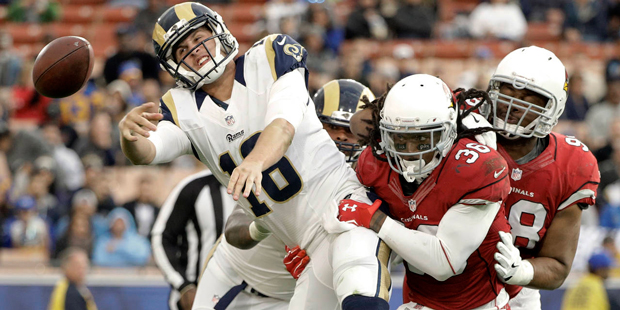 Los Angeles Rams quarterback Jared Goff, left, throws under pressure from Arizona Cardinals free sa...