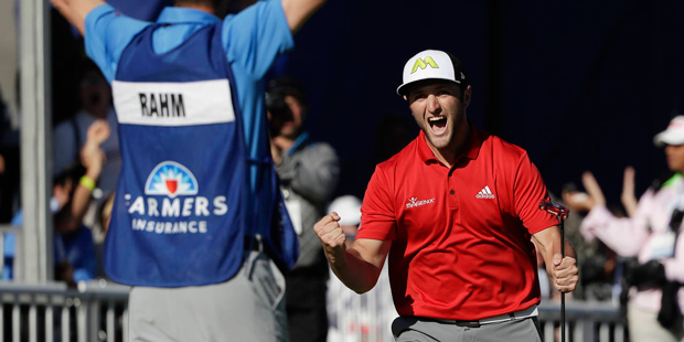 Jon Rahm, right, of Spain, reacts after making a putt for eagle on the 18th hole of the South Cours...