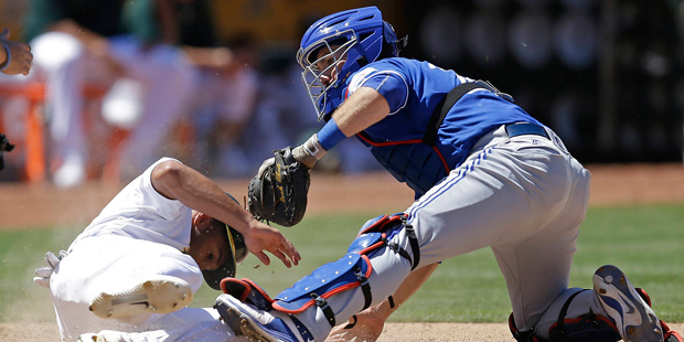 Toronto Blue Jays catcher Josh Thole, right, tags out Oakland Athletics' Marcus Semien in the seven...