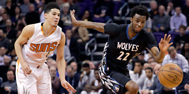 Minnesota Timberwolves forward Andrew Wiggins (22) and Phoenix Suns guard Devin Booker (1) chase do...