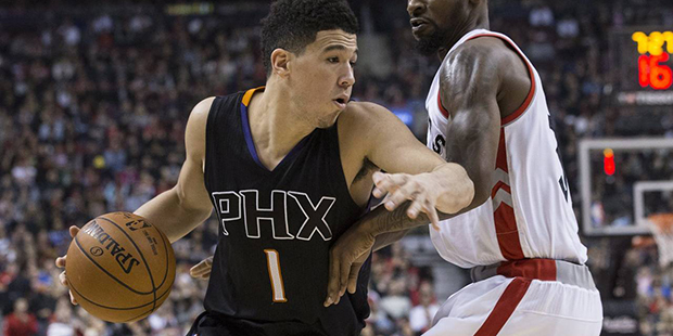 Phoenix Suns guard Devin Booker, left, drives against Toronto Raptors' Terrence Ross during first-h...