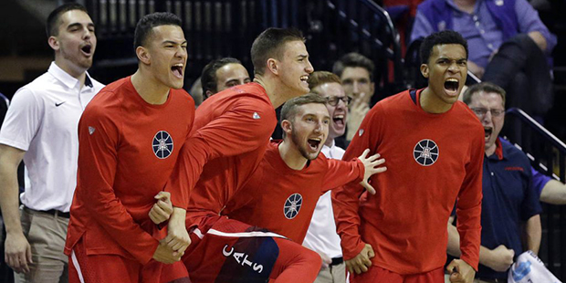 Players on the Arizona bench cheer a dunk against Washington late in the second half of an NCAA col...