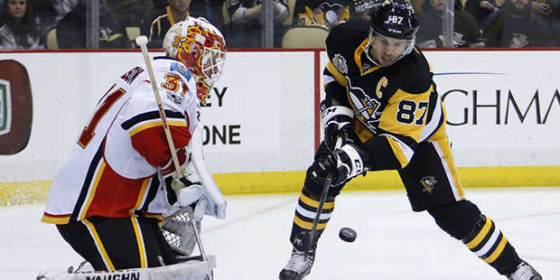 Pittsburgh Penguins' Sidney Crosby (87) can't get a shot past Calgary Flames goalie Chad Johnson du...