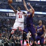 Chicago Bulls' Jimmy Butler (21) scores past Phoenix Suns' Alex Len (21) as TJ Warren watches during the first half of an NBA basketball game Friday, Feb. 24, 2017, in Chicago. (AP Photo/Charles Rex Arbogast)