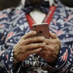 New England Patriots fan Jason Woolley, of Murrieta, Calif., looks at his phone before the NFL Super Bowl 51 football game between the Patriots and the Atlanta Falcons, Sunday, Feb. 5, 2017, in Houston. (AP Photo/Jae C. Hong)