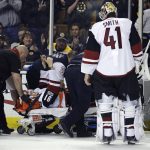 Arizona Coyotes center Alexander Burmistrov (91) flashes a thumbs-up as he is taken off the ice on a stretcher following a hit by Boston Bruins defenseman Colin Miller during the second period of an NHL hockey game in Boston, Tuesday, Feb. 28, 2017. At front is Arizona Coyotes goalie Mike Smith (41). (AP Photo/Charles Krupa)