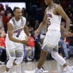 Arizona's Parker Jackson-Cartwright (0) and Allonzo Trier celebrate after Arizona defeated Southern California 90-77 during an NCAA college basketball game, Thursday, Feb. 23, 2017, in Tucson, Ariz. (AP Photo/Rick Scuteri)