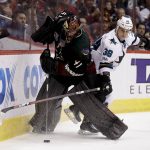 Arizona Coyotes goalie Mike Smith, left, vies for the puck with San Jose Sharks center Micheal Haley during the third period of an NHL hockey game in Glendale, Ariz., Saturday, Feb. 18, 2017. (AP Photo/Chris Carlson)