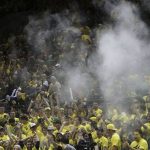 Powder floats over the Oregon student section after fans threw a substance in to air following Oregon's first score against Arizona during an NCAA college basketball game Saturday, Feb. 4, 2017, in Eugene, Ore. The incident delayed the game and led the refs to issue a warning to Oregon. (AP Photo/Chris Pietsch)
