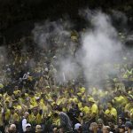 Powder floats over the Oregon student section after fans threw a substance in to air following Oregon's first score against Arizona during an NCAA college basketball game Saturday, Feb. 4, 2017, in Eugene, Ore. The incident delayed the game and led the refs to issue a warning to Oregon. (AP Photo/Chris Pietsch)
