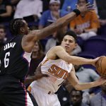 Phoenix Suns guard Devin Booker (1) passes around Los Angeles Clippers center DeAndre Jordan (6) during the first half of an NBA basketball game, Wednesday, Feb. 1, 2017, in Phoenix. (AP Photo/Matt York)