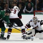 Arizona Coyotes goalie Louis Domingue eyes the puck as Dallas Stars' Antoine Roussel (21) and Oliver Ekman-Larsson (23) battle during the second period of an NHL hockey game, Friday, Feb. 24, 2017, in Dallas. (AP Photo/Mike Stone)