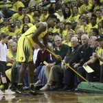 Oregon's Jordan Bell helps clean up after Duck fans threw powder on the floor after the first score against Arizona in an NCAA college basketball game Saturday, Feb. 4, 2017, in Eugene, Ore. The incident lead to a delay of the game and a warning from officials. (AP Photo/Chris Pietsch)