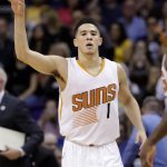 Phoenix Suns guard Devin Booker signals after making a 3-pointer against the Los Angeles Lakers during the first half of an NBA basketball game, Wednesday, Feb. 15, 2017, in Phoenix. (AP Photo/Matt York)