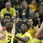Arizona's Kobi Simmons, top left, looks for teammate Dusan Ristic, right, under pressure from Oregon's Casey Benson, foreground, and Chris Boucher, right, during the first half of an NCAA college basketball game Saturday, Feb. 4, 2017, in Eugene, Ore. (AP Photo/Chris Pietsch)