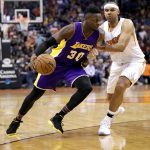Los Angeles Lakers forward Julius Randle (30) drives past Phoenix Suns forward Jared Dudley during the first half of an NBA basketball game, Wednesday, Feb. 15, 2017, in Phoenix. (AP Photo/Matt York)