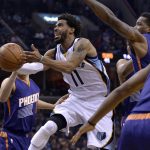 Memphis Grizzlies guard Mike Conley (11) shoots between Phoenix Suns guards Eric Bledsoe, second from right, and Devin Booker (1) in the second half of an NBA basketball game Wednesday, Feb. 8, 2017, in Memphis, Tenn. (AP Photo/Brandon Dill)