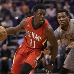 New Orleans Pelicans guard Jrue Holiday (11) drives on Phoenix Suns guard Eric Bledsoe in the first quarter during an NBA basketball game, Monday, Feb. 13, 2017, in Phoenix. (AP Photo/Rick Scuteri)
