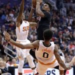 Chicago Bulls forward Jimmy Butler (21) fouls Phoenix Suns forward Marquese Chriss (0) as he drives to the basket during the first half of an NBA basketball game, Friday, Feb. 10, 2017, in Phoenix. (AP Photo/Matt York)