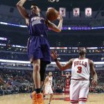 Phoenix Suns' Devin Booker (1) dunks as Chicago Bulls' Dwyane Wade watches during the first half of an NBA basketball game Friday, Feb. 24, 2017, in Chicago. (AP Photo/Charles Rex Arbogast)