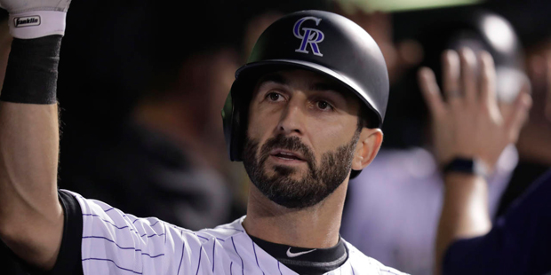 Colorado Rockies' Daniel Descalso is congratulated as he returns to the dugout after hitting a two-...