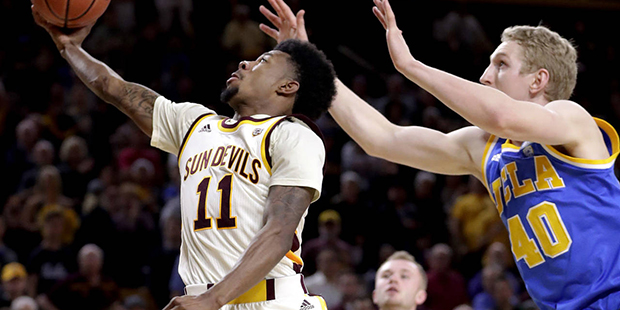 Arizona State guard Shannon Evans II (11) drives past UCLA center Thomas Welsh (40) during the seco...
