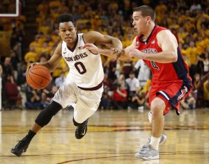 Arizona State guard Tra Holder (0) drives on Arizona guard T.J. McConnell during the second half of an NCAA college basketball game, Saturday, Feb. 7, 2015, in Tempe, Ariz. (AP Photo/Rick Scuteri)