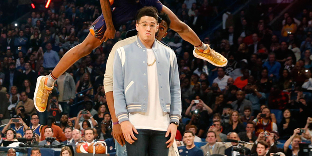 Phoenix Suns' Derrick Jones, Jr. leaps over teammates during the slam dunk contest at NBA All-Star ...