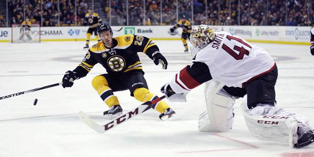 Arizona Coyotes goalie Mike Smith (41) reaches out and knocks the puck away from Boston Bruins cent...