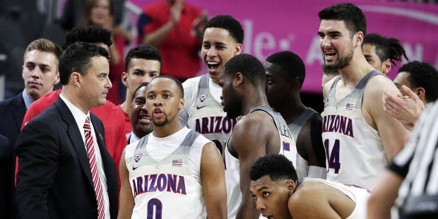 Arizona coach Sean Miller, left, speaks with his players during the second half of an NCAA college ...