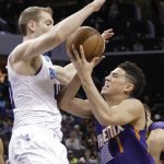 Phoenix Suns' Devin Booker, right, drives against Charlotte Hornets' Cody Zeller, left, in the first half of an NBA basketball game in Charlotte, N.C., Sunday, March 26, 2017. (AP Photo/Chuck Burton)