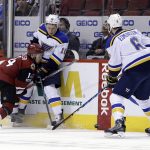 Arizona Coyotes center Clayton Keller (14) and St. Louis Blues right wing Scottie Upshall (10) battle for the loose puck in the second period during an NHL hockey game, Wednesday, March 29, 2017, in Glendale, Ariz. (AP Photo/Rick Scuteri)