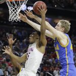 UCLA's Thomas Welsh, right, fouls Arizona's Allonzo Trier during the first half of an NCAA college basketball game in the semifinals of the Pac-12 men's tournament Friday, March 10, 2017, in Las Vegas. (AP Photo/John Locher)