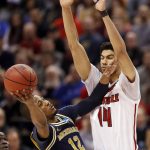Michigan's Muhammad-Ali Abdur-Rahkman (12) heads to the basket as Louisville's Anas Mahmoud (14) defends during the second half of a second-round game in the men's NCAA college basketball tournament Sunday, March 19, 2017, in Indianapolis. Michigan won 73-69. (AP Photo/Jeff Roberson)