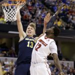 Michigan forward Moritz Wagner (13) shoots over Louisville forward Mangok Mathiang (12) during the second half of a second-round game in the men's NCAA college basketball tournament in Indianapolis, Sunday, March 19, 2017. Michigan defeated Louisville 73-69. (AP Photo/Michael Conroy)