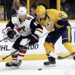 Arizona Coyotes left wing Jamie McGinn (88) and Nashville Predators center Mike Fisher (12) battle for the puck during the first period of an NHL hockey game Monday, March 20, 2017, in Nashville, Tenn. (AP Photo/Mark Humphrey)