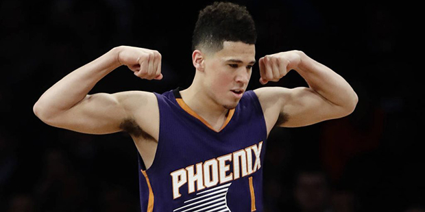 Phoenix Suns' Devin Booker (1) celebrates after scoring during the first half of the team's NBA bas...