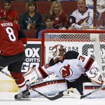 Arizona Coyotes right wing Tobias Rieder (8) scores a goal against New Jersey Devils goalie Cory Schneider, right, as Devils' Steven Santini, left, defends during the first period of an NHL hockey game Saturday, March 11, 2017, in Glendale, Ariz. (AP Photo/Ross D. Franklin)