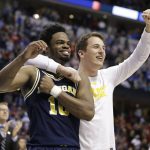 Michigan guard Derrick Walton Jr. (10) and guard Andrew Dakich (11) celebrate following a 73-69 win over Louisville in a second-round game in the men's NCAA college basketball tournament in Indianapolis, Sunday, March 19, 2017.  (AP Photo/Michael Conroy)