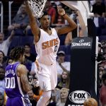 Phoenix Suns forward Marquese Chriss (0) signals to a teammate after dunking as Sacramento Kings center Willie Cauley-Stein (00) defends during the first half of an NBA basketball game, Wednesday, March 15, 2017, in Phoenix. (AP Photo/Matt York)