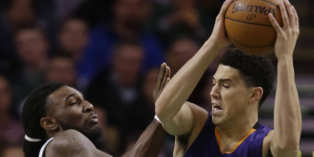 Phoenix Suns guard Devin Booker (1) moves toward the hoop against Boston Celtics forward Jae Crowde...