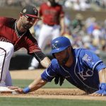 Kansas City Royals' Alex Gordon dives safe back to first as Arizona Diamondbacks' Daniel Descalso applies the tag during the second inning of a spring training baseball game Tuesday, March 21, 2017, in Scottsdale, Ariz. (AP Photo/Darron Cummings)