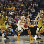 West Virginia forward Nathan Adrian (11) handles the ball against Notre Dame guard Temple Gibbs (2) and guard Matt Farrell (5) during the second half of a second-round men's college basketball game in the NCAA Tournament, Saturday, March 18, 2017, in Buffalo, N.Y. West Virginia won, 83-71. (AP Photo/Bill Wippert)