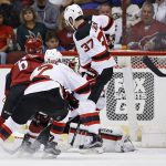 Arizona Coyotes defenseman Jakob Chychrun (6) gets the puck past New Jersey Devils center Pavel Zacha (37), John Moore (2) and goalie Cory Schneider, right, for a goal during the first period of an NHL hockey game Saturday, March 11, 2017, in Glendale, Ariz. (AP Photo/Ross D. Franklin)