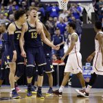 Michigan forwards D.J. Wilson (5) and Moritz Wagner (13) celebrates during the second half of a second-round game against Louisville in the men's NCAA college basketball tournament in Indianapolis, Sunday, March 19, 2017. Michigan defeated Louisville 73-69. (AP Photo/Michael Conroy)